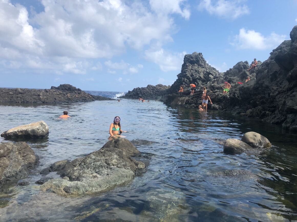 child swimming at rocky beach